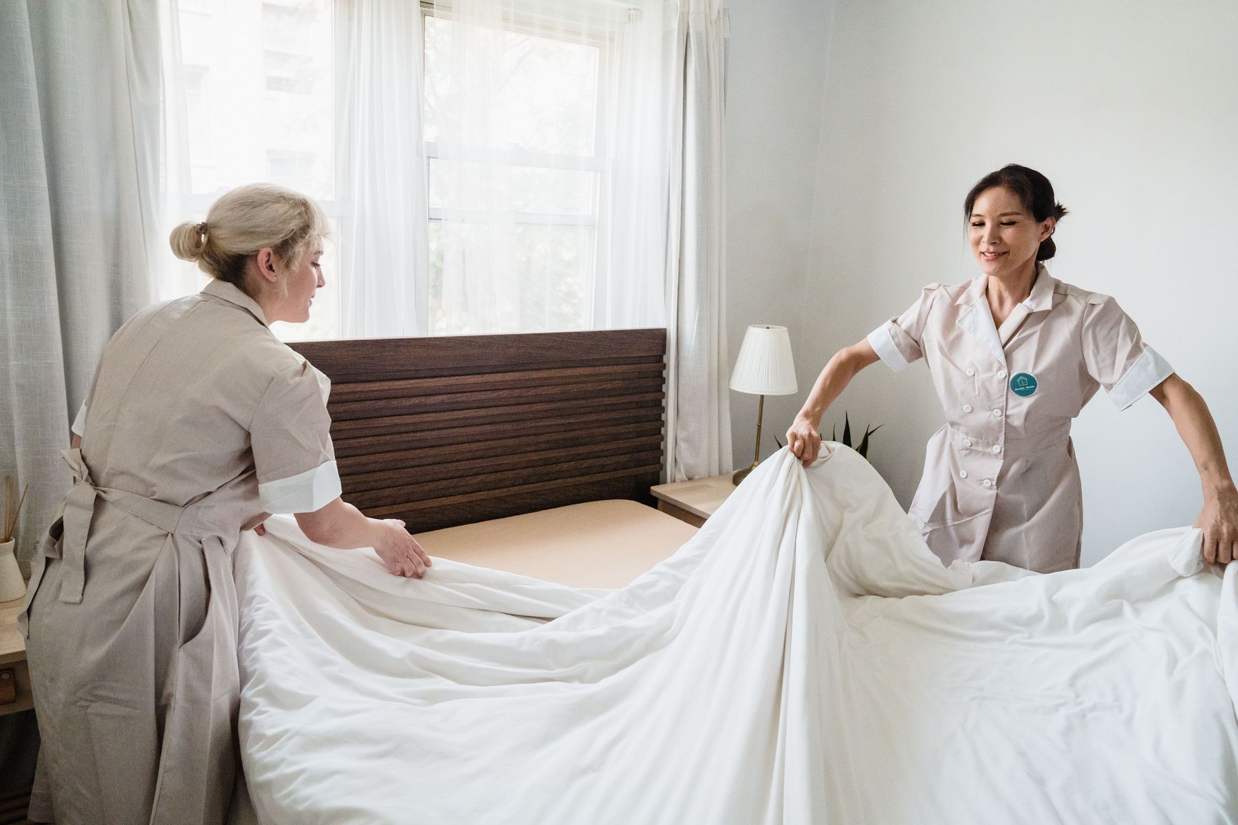 Housekeeping staff making up a hotel room